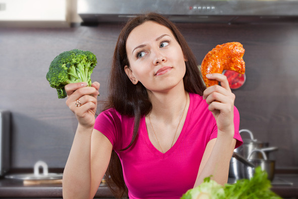 kvinde i køkken med grønsag og kylling